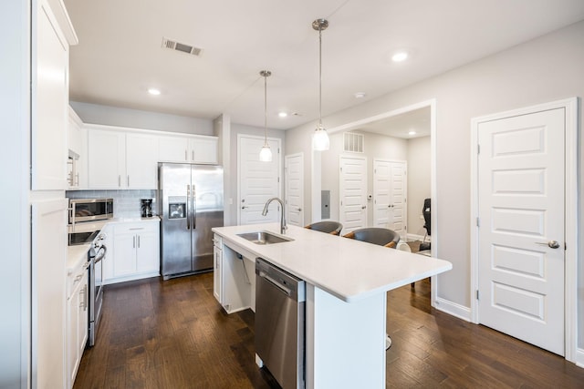 kitchen featuring decorative light fixtures, sink, white cabinetry, an island with sink, and stainless steel appliances