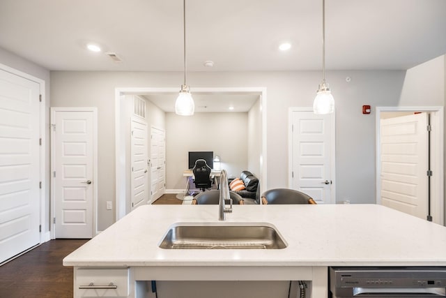 kitchen featuring a center island with sink, decorative light fixtures, dark wood-type flooring, dishwasher, and sink