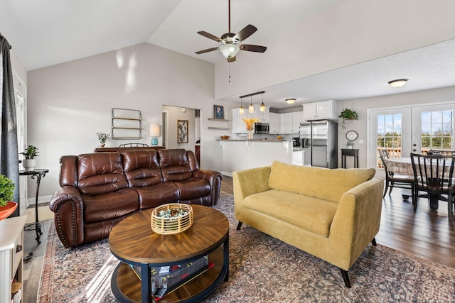 living room with ceiling fan, dark hardwood / wood-style floors, french doors, and vaulted ceiling