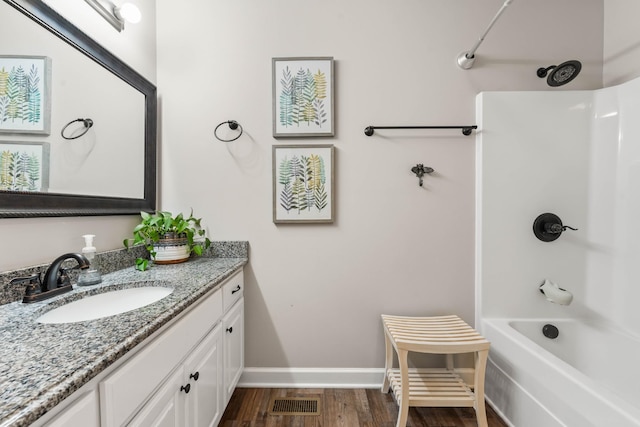 bathroom with hardwood / wood-style flooring, vanity, and shower / bathing tub combination