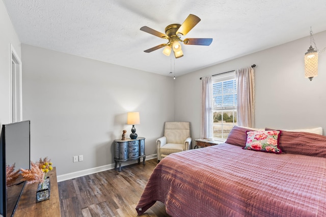 bedroom with ceiling fan, a textured ceiling, and dark hardwood / wood-style flooring