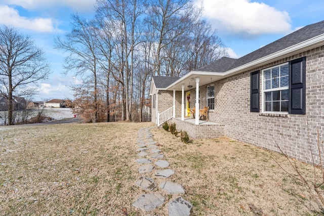 view of home's exterior featuring covered porch and a yard