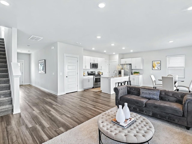 living room with dark hardwood / wood-style flooring and sink