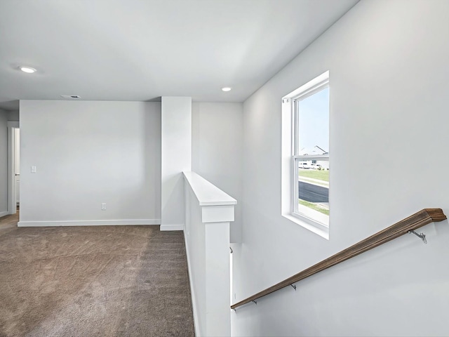 corridor with a healthy amount of sunlight and carpet flooring