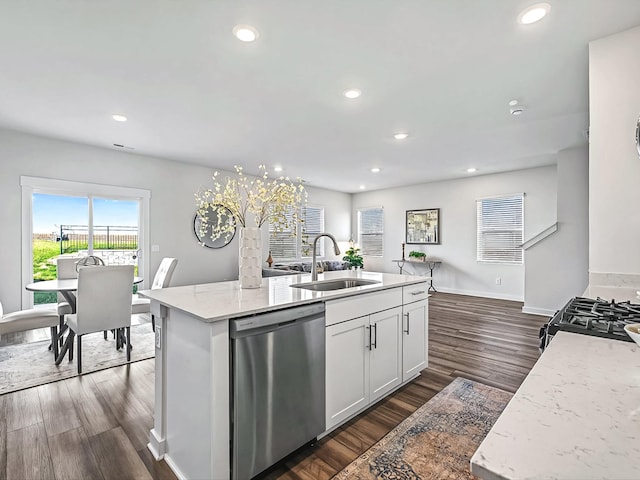 kitchen with sink, dishwasher, an island with sink, light stone countertops, and white cabinets