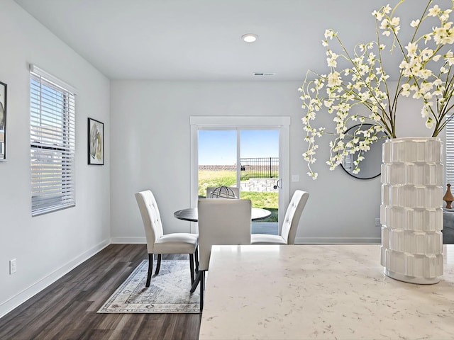 dining area featuring dark wood-type flooring and plenty of natural light