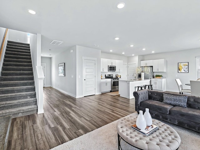 living room featuring sink and dark hardwood / wood-style flooring