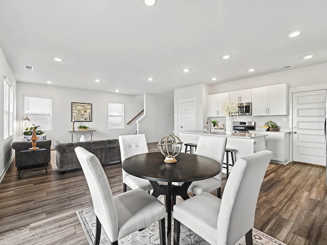 dining space with sink and hardwood / wood-style floors