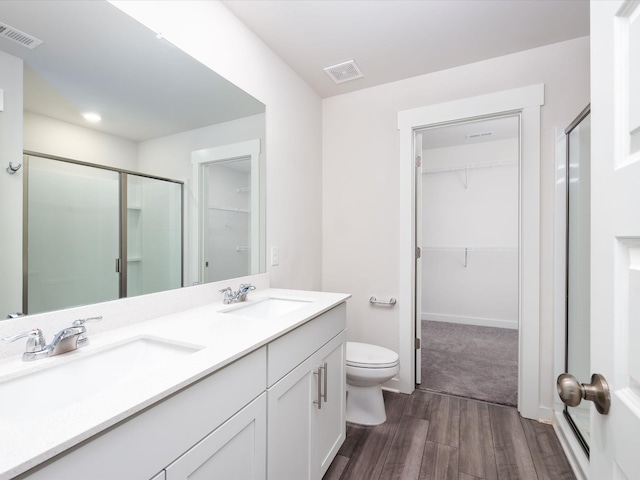 bathroom featuring vanity, an enclosed shower, and toilet