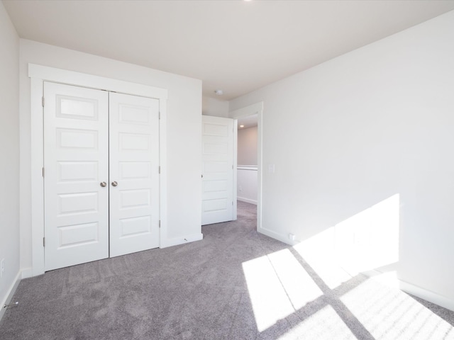 unfurnished bedroom with light carpet and a closet