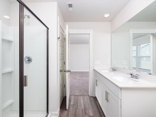 bathroom featuring wood-type flooring, vanity, and walk in shower