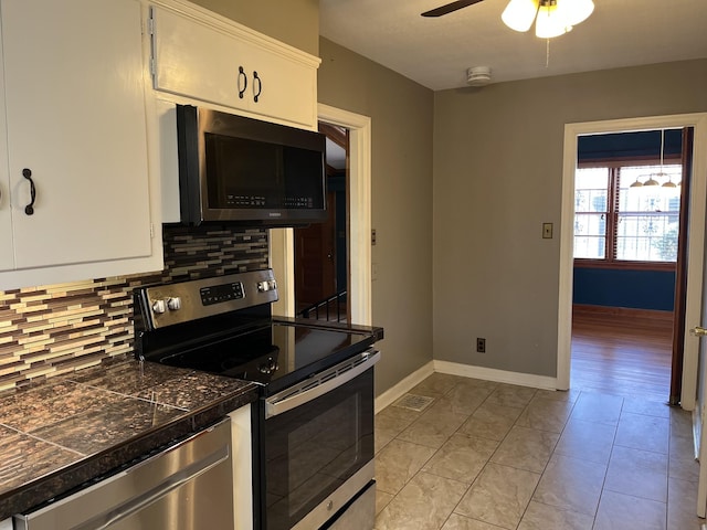 kitchen with tasteful backsplash, ceiling fan, light tile patterned floors, stainless steel appliances, and white cabinets