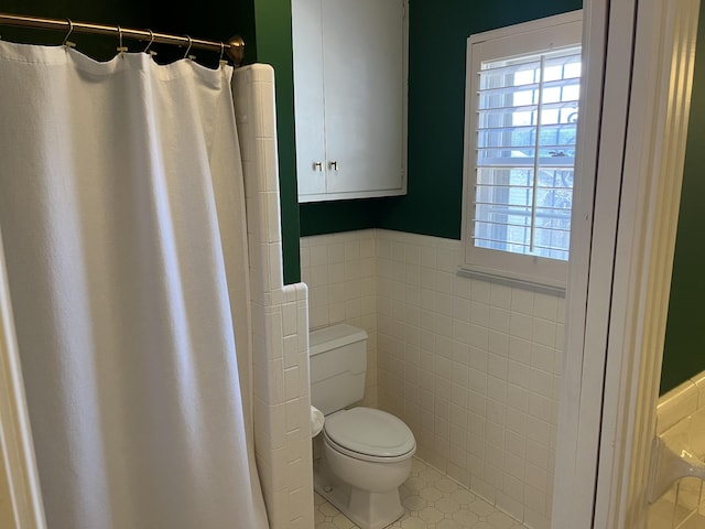 bathroom featuring tile walls, toilet, a shower with shower curtain, and tile patterned flooring