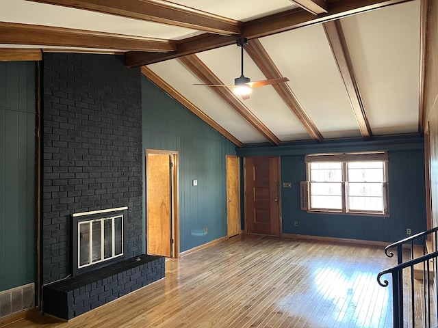 unfurnished living room featuring vaulted ceiling with beams, a fireplace, wood-type flooring, and ceiling fan