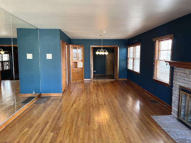 interior space featuring a chandelier, a fireplace, and wood-type flooring