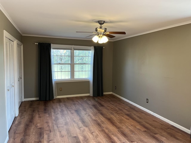 unfurnished room featuring dark wood-type flooring, ornamental molding, and ceiling fan