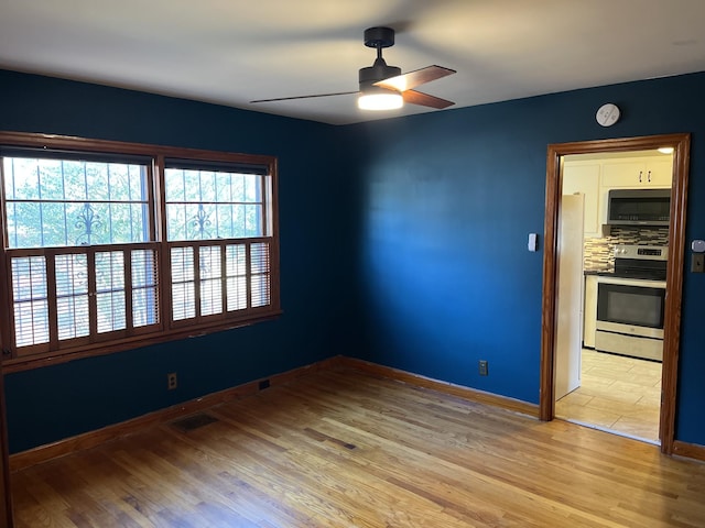 spare room featuring ceiling fan and light hardwood / wood-style floors