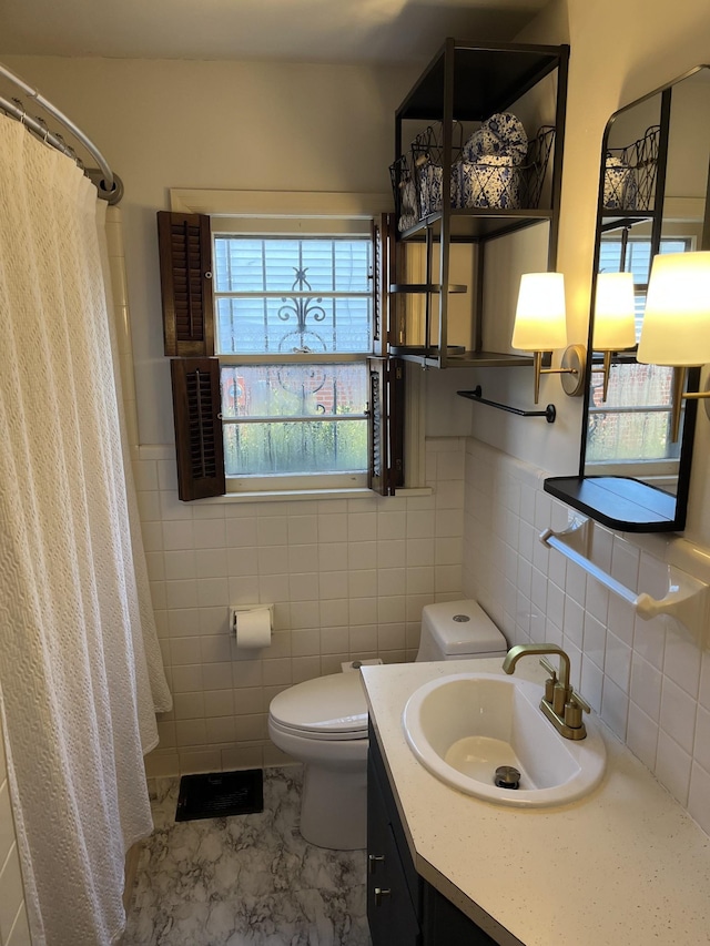 bathroom featuring toilet, vanity, tile walls, tile patterned flooring, and a shower with curtain