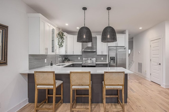 kitchen with sink, stainless steel appliances, kitchen peninsula, and white cabinets