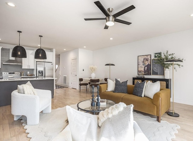 living room with ceiling fan and light hardwood / wood-style floors