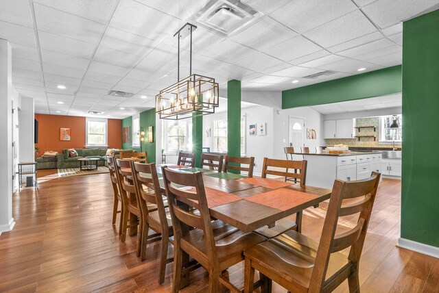 dining area featuring a drop ceiling and dark hardwood / wood-style floors