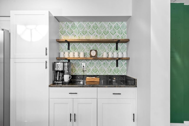 bar featuring white cabinets, backsplash, and dark stone counters