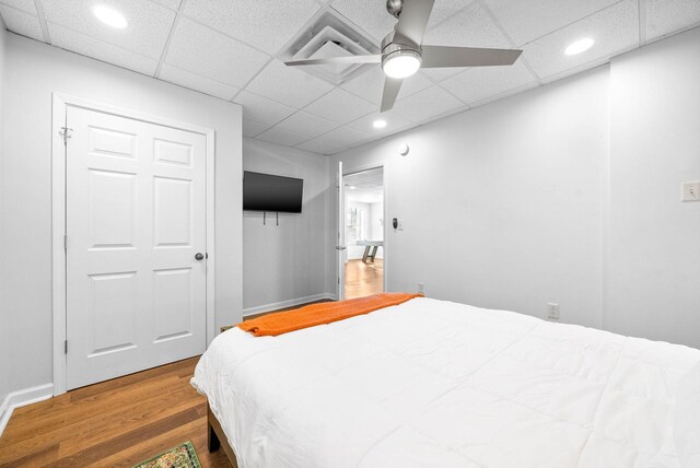 bedroom with ceiling fan, a closet, and hardwood / wood-style floors