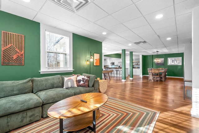 living room featuring a drop ceiling and hardwood / wood-style flooring