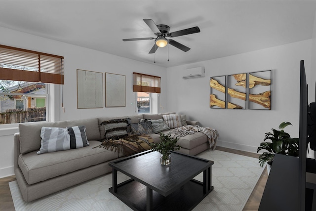 living room with light hardwood / wood-style floors, ceiling fan, and a wall mounted air conditioner