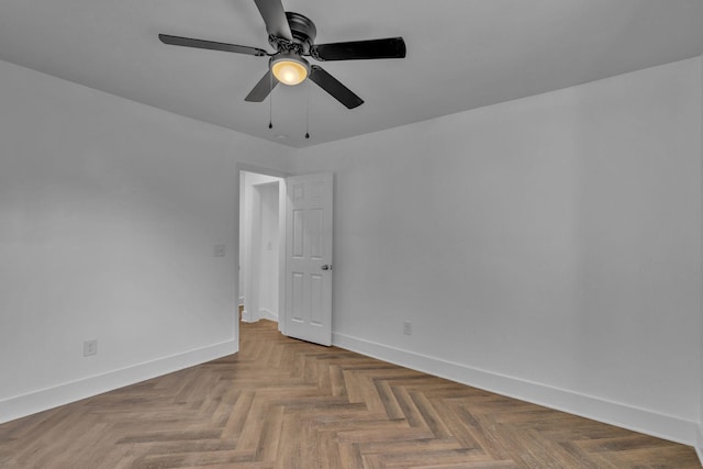 spare room featuring ceiling fan and parquet flooring