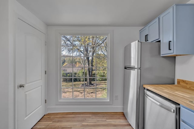 kitchen featuring butcher block countertops, light wood-type flooring, and appliances with stainless steel finishes