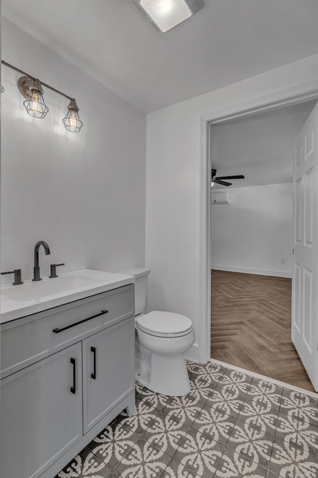 bathroom featuring toilet, vanity, and ceiling fan