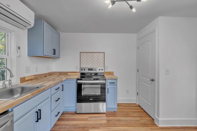 kitchen with wood counters, stainless steel appliances, sink, a wall mounted AC, and light hardwood / wood-style flooring