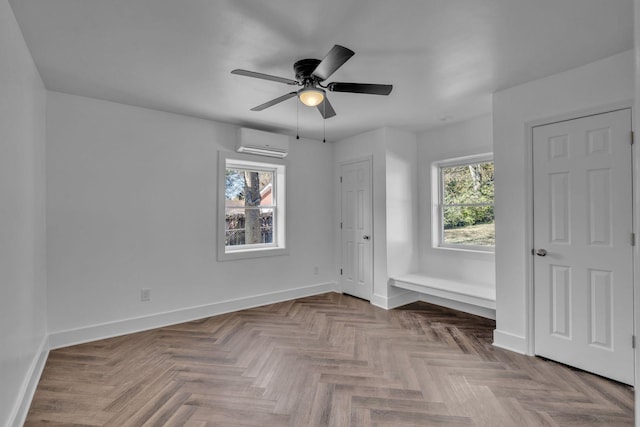 unfurnished bedroom featuring ceiling fan, parquet flooring, and an AC wall unit