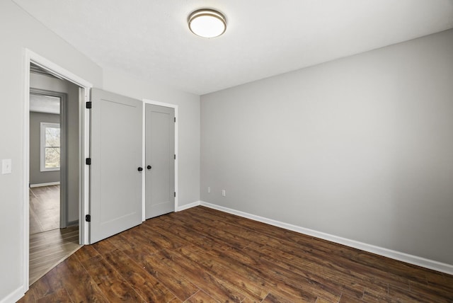 unfurnished bedroom with dark wood-type flooring