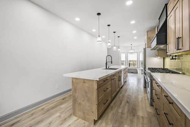 kitchen featuring sink, stainless steel range, pendant lighting, a large island, and backsplash