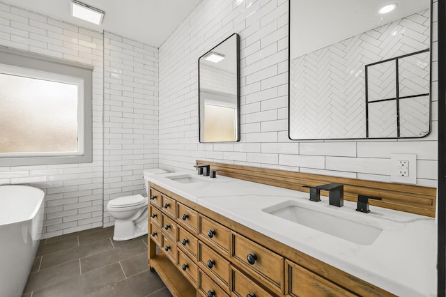 full bathroom with vanity, tile patterned floors, tile walls, and toilet