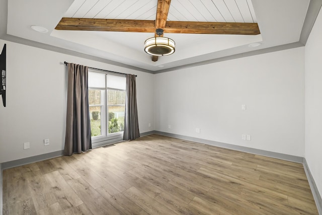 unfurnished room with a raised ceiling, wood ceiling, and light hardwood / wood-style floors