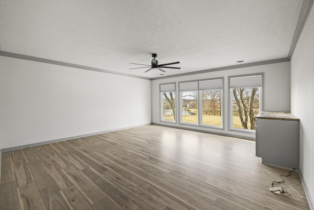 unfurnished living room featuring light hardwood / wood-style flooring, crown molding, a wealth of natural light, and a textured ceiling