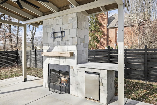 view of patio / terrace featuring ceiling fan and an outdoor stone fireplace