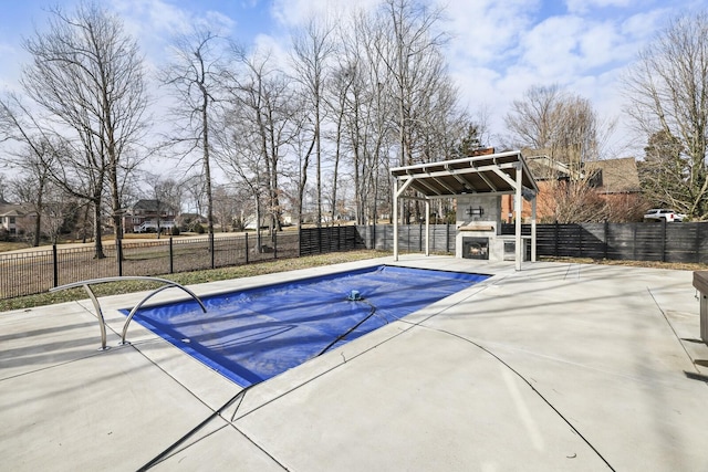 view of swimming pool with an outdoor fireplace and a patio