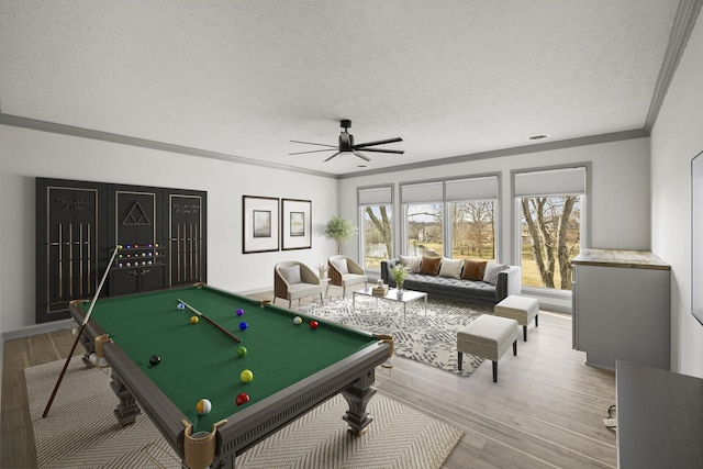 recreation room with ceiling fan, ornamental molding, a textured ceiling, pool table, and light wood-type flooring