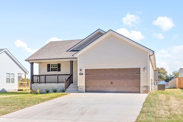 view of front facade with a front yard, covered porch, and a garage