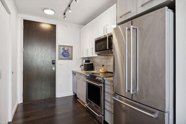 kitchen featuring dark wood-type flooring, white cabinets, tasteful backsplash, and high quality appliances