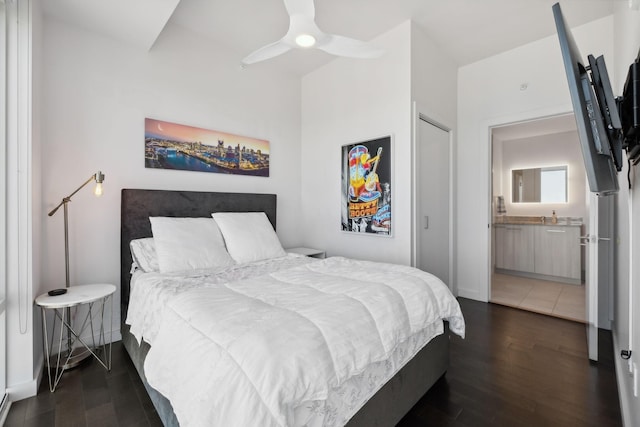 bedroom with ceiling fan, dark hardwood / wood-style flooring, and connected bathroom