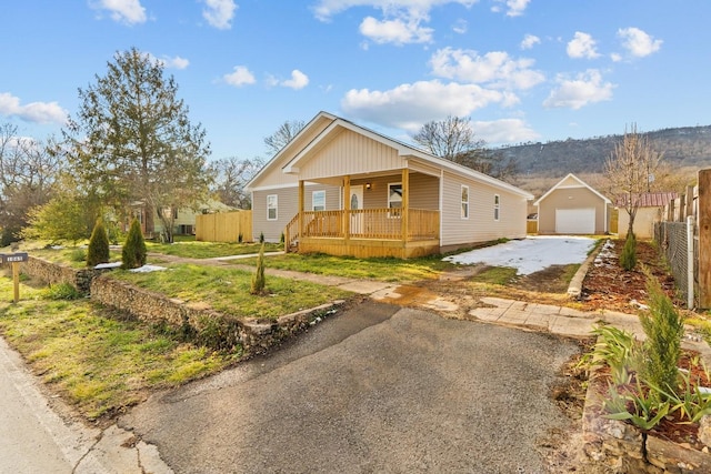 view of front of home with a front yard, an outdoor structure, a porch, and a garage