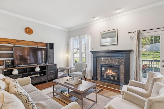 living room featuring a high end fireplace, ornamental molding, and light hardwood / wood-style floors