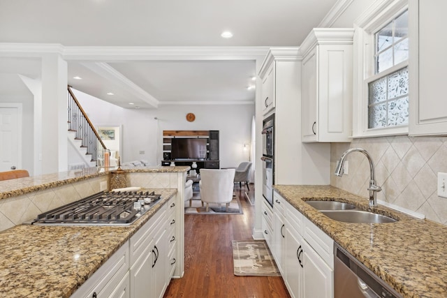 kitchen with white cabinetry, appliances with stainless steel finishes, dark hardwood / wood-style floors, ornamental molding, and sink