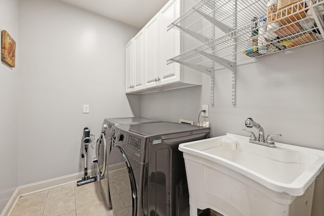 laundry area with cabinets, sink, washer and clothes dryer, and light tile patterned flooring