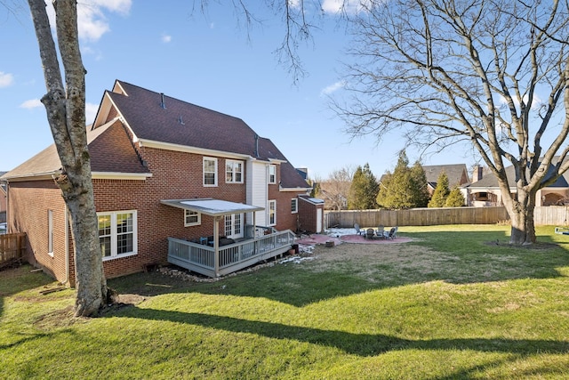 back of property with a lawn and a wooden deck